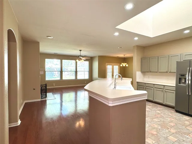 a large kitchen with a sink and a large window