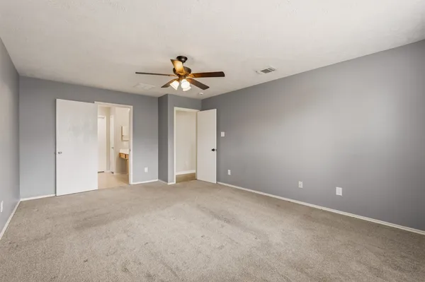 a view of a big room with chandelier fan and windows