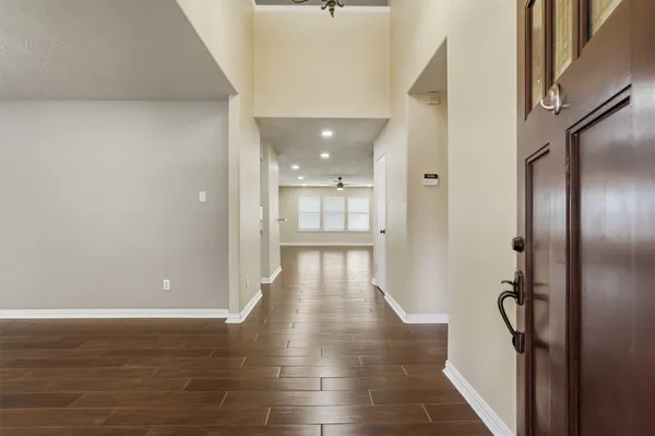 a view of a hallway with wooden floor and staircase