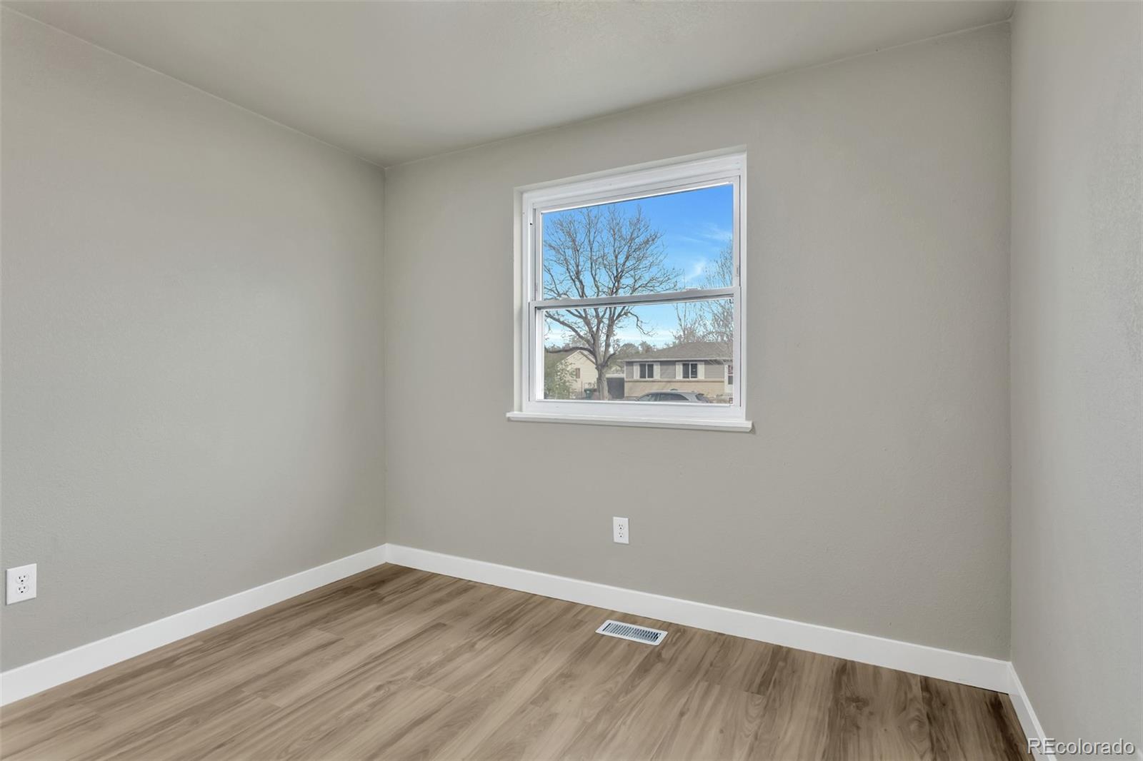 2787 South Helena Way Aurora, CO 80013 - Photo 11 of 26 a view of an empty room with wooden floor and a window