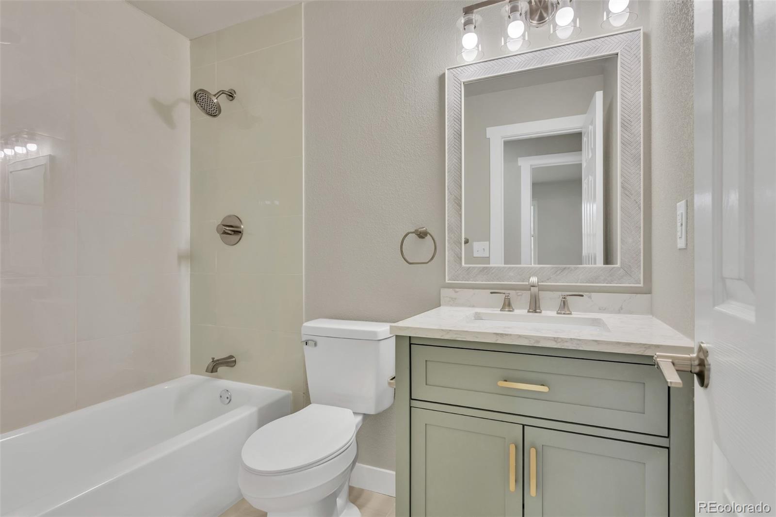 2787 South Helena Way Aurora, CO 80013 - Photo 13 of 26 a bathroom with a toilet sink vanity tub and mirror