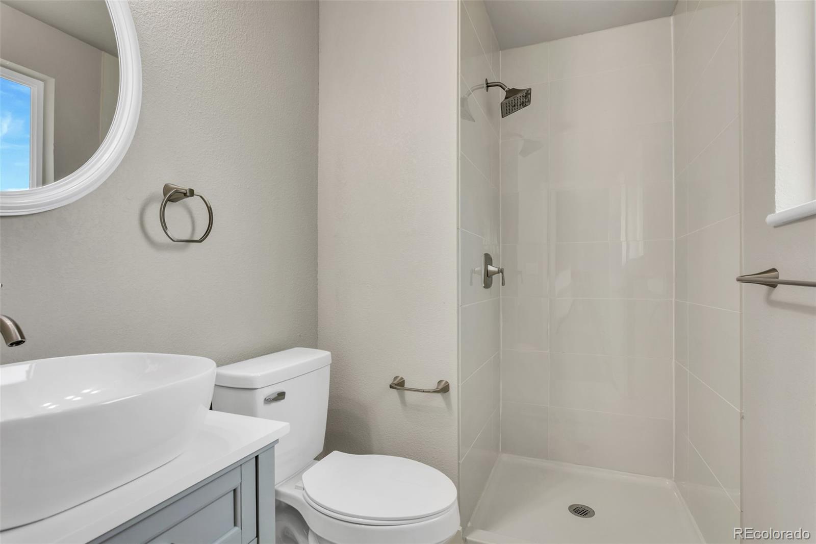 2787 South Helena Way Aurora, CO 80013 - Photo 16 of 26 a white toilet sitting next to a bathroom sink