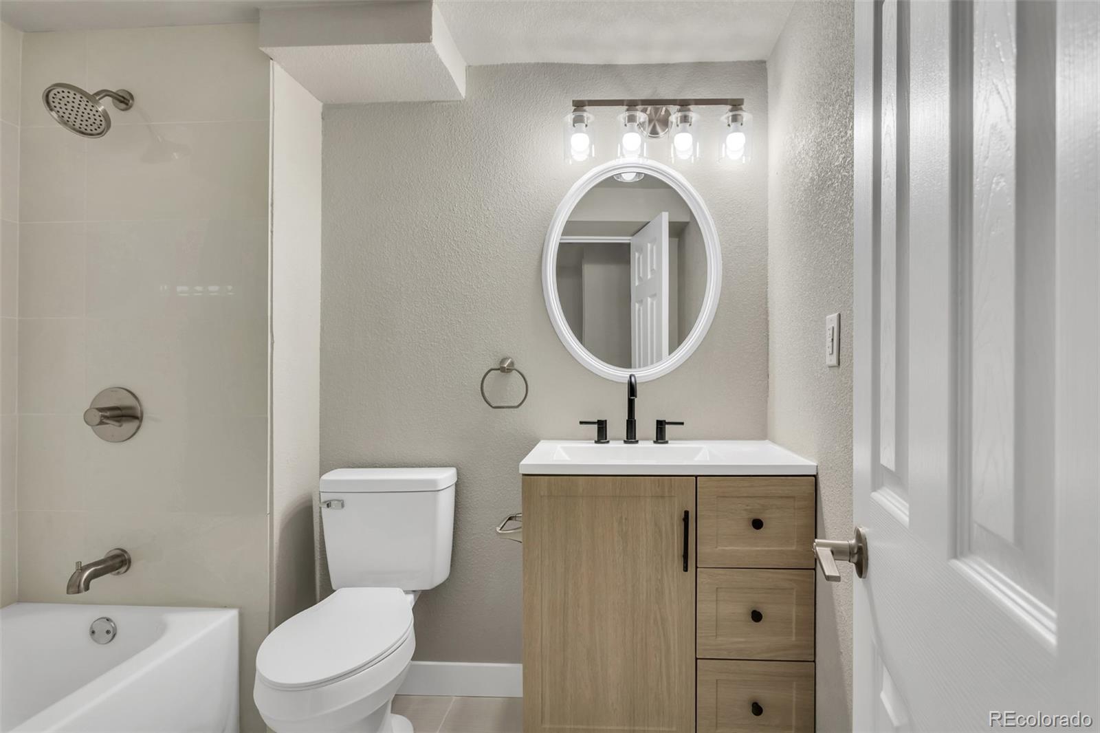 2787 South Helena Way Aurora, CO 80013 - Photo 21 of 26 a bathroom with a toilet a sink and a mirror