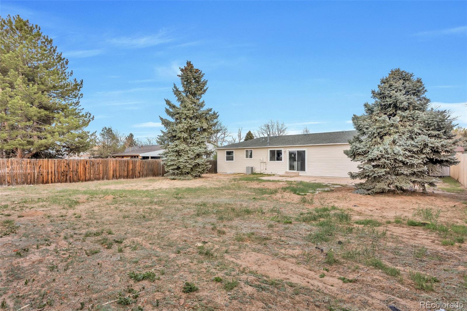 2787 South Helena Way Aurora, CO 80013 - Photo 26 of 26 a white house that has a big yard with wooden fence