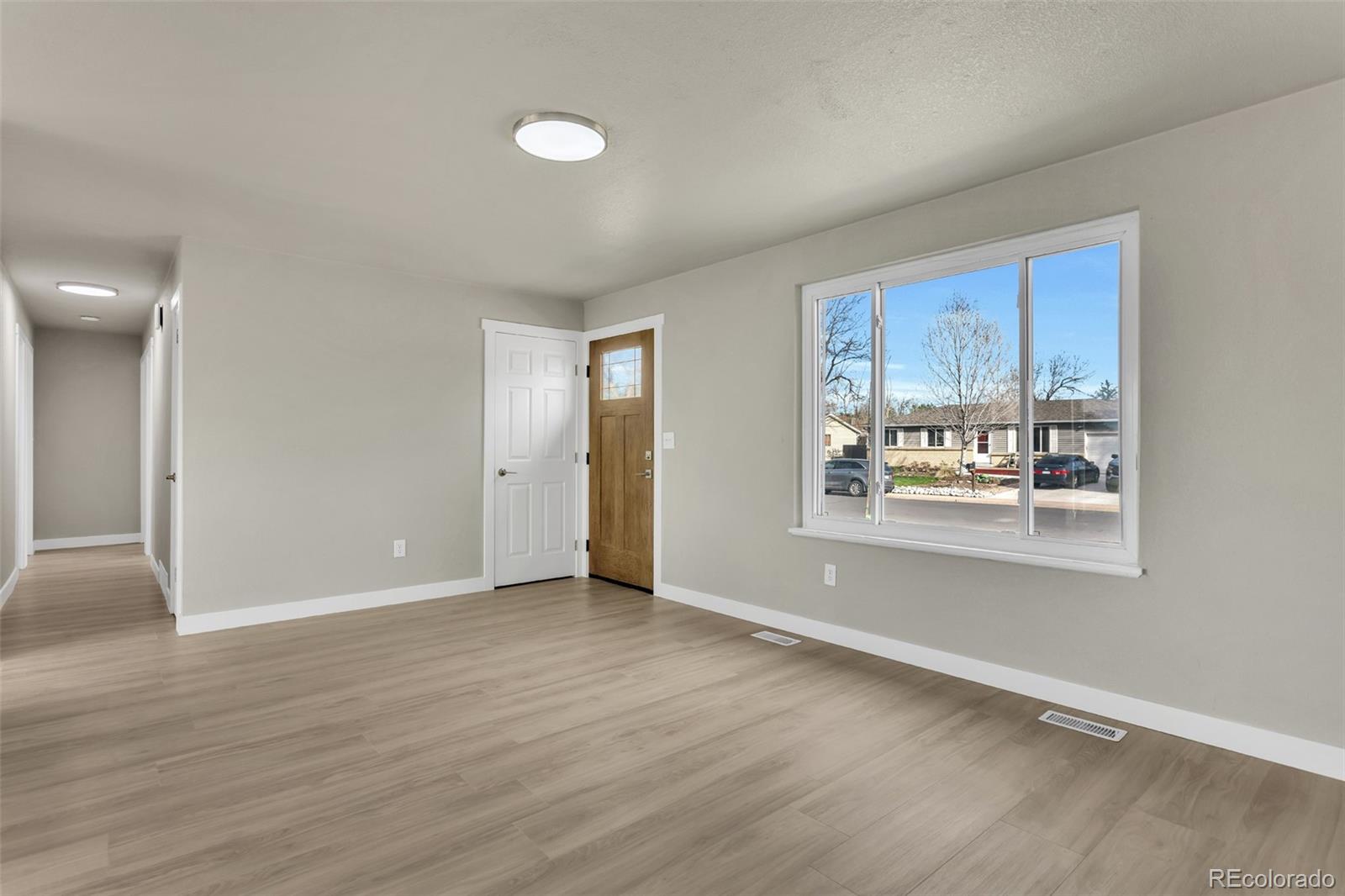 2787 South Helena Way Aurora, CO 80013 - Photo 4 of 26 a view of an empty room with wooden floor and a window