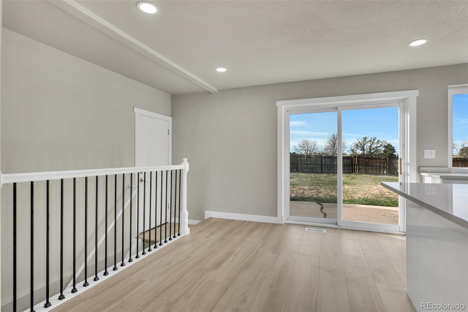 2787 South Helena Way Aurora, CO 80013 - Photo 5 of 26 a view of an empty room with wooden floor and a window