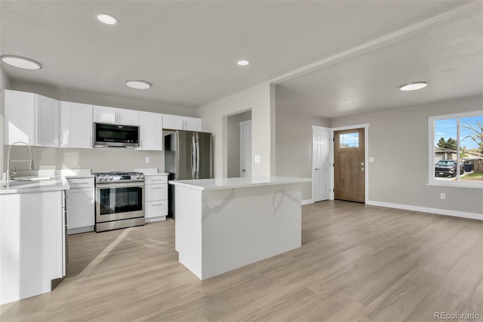 2787 South Helena Way Aurora, CO 80013 - Photo 6 of 26 a living room with stainless steel appliances furniture a fireplace and a flat screen tv