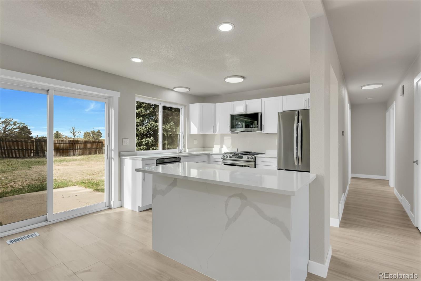 2787 South Helena Way Aurora, CO 80013 - Photo 7 of 26 a kitchen with stainless steel appliances a refrigerator a sink a stove and cabinets