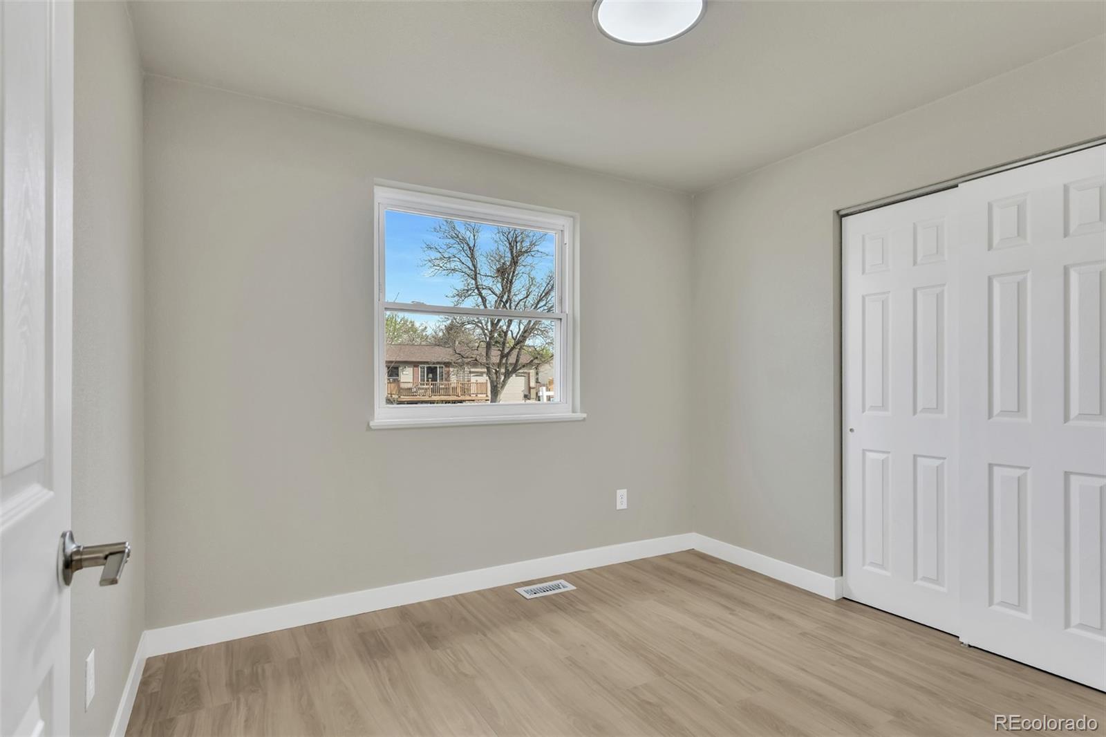 2787 South Helena Way Aurora, CO 80013 - Photo 10 of 26 an empty room with wooden floor and window