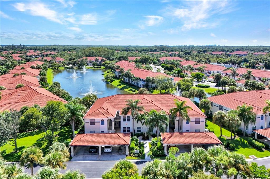 an aerial view of a houses with a garden and lake view