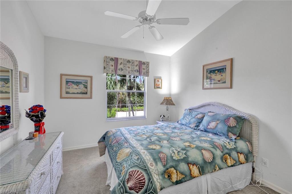 10711 Halfmoon Shoal Road, Unit 203 Estero, FL 34135 - Photo 15 of 25 a bedroom with a bed and a chandelier