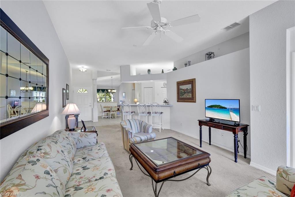 10711 Halfmoon Shoal Road, Unit 203 Estero, FL 34135 - Photo 19 of 25 a living room with furniture and a flat screen tv