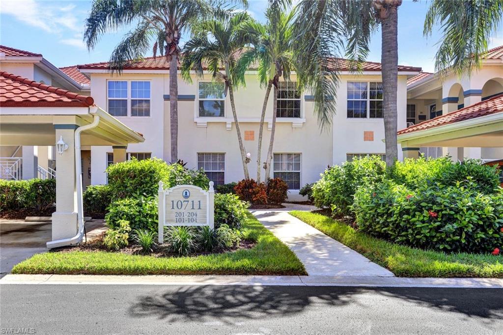 10711 Halfmoon Shoal Road, Unit 203 Estero, FL 34135 - Photo 25 of 25 a front view of a house with a yard and potted plants