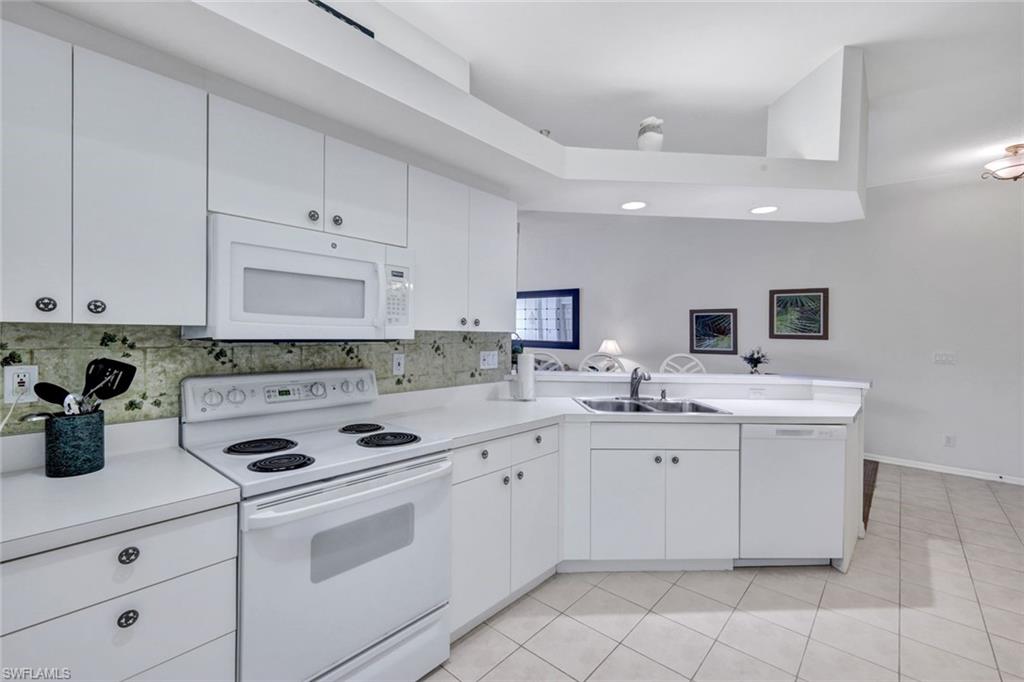 10711 Halfmoon Shoal Road, Unit 203 Estero, FL 34135 - Photo 10 of 25 a kitchen with a sink stove and cabinets