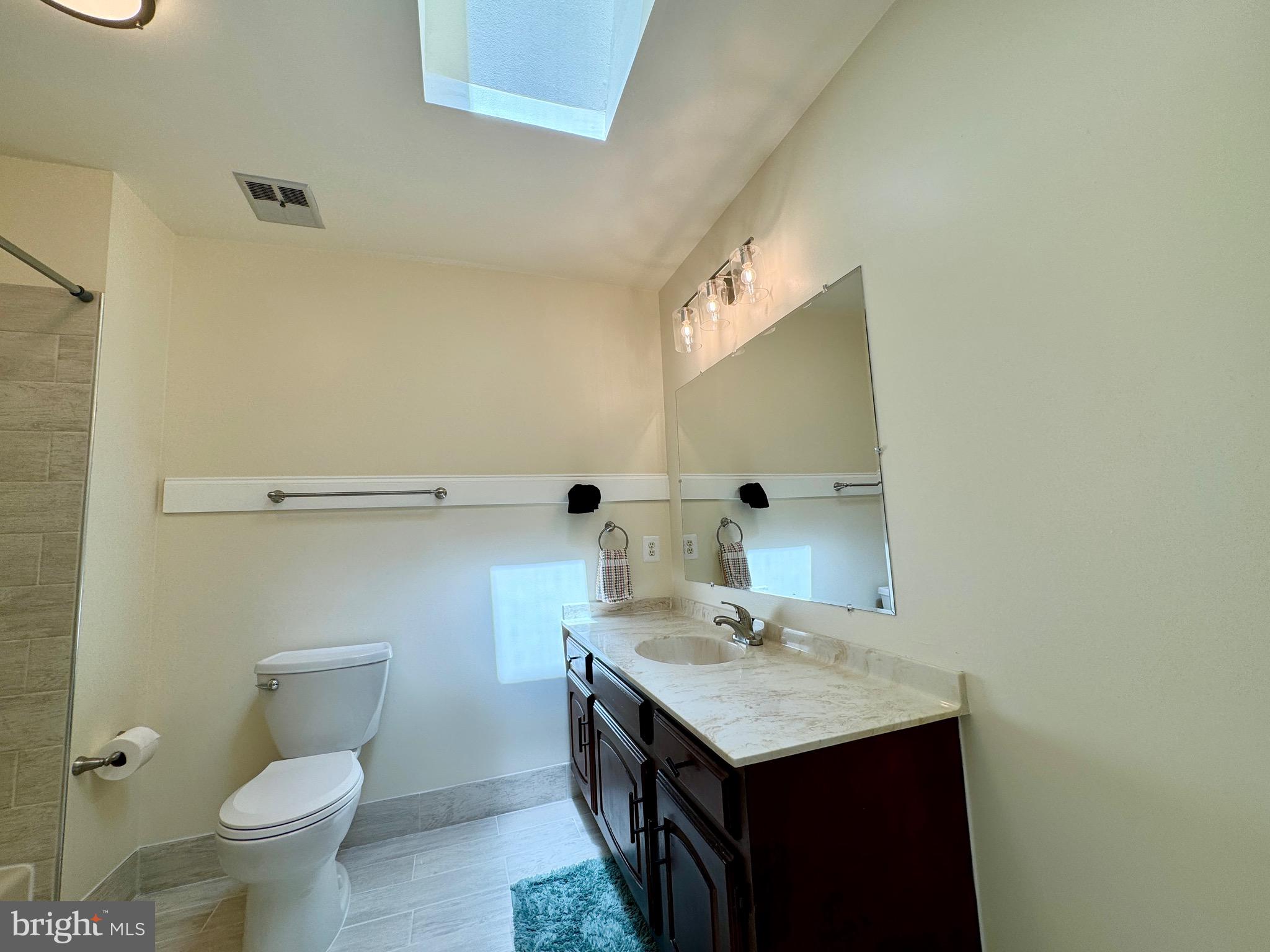 6728 Churchill Road McLean, VA 22101 - Photo 13 of 32 a bathroom with a granite countertop sink a toilet and a mirror