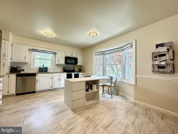 a kitchen with a stove top oven a sink a dining table and chairs