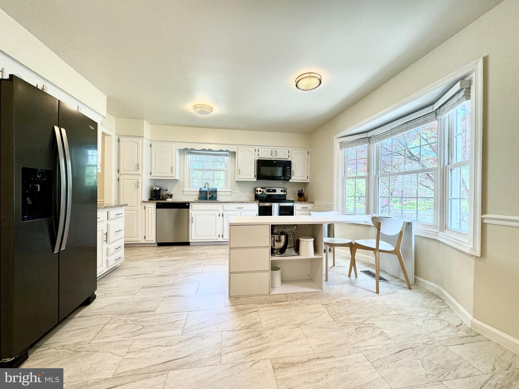 6728 Churchill Road McLean, VA 22101 - Photo 4 of 32 a kitchen with granite countertop a refrigerator stove microwave and cabinets
