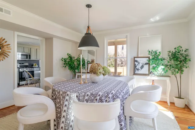 a kitchen with stainless steel appliances granite countertop a stove a kitchen island a dining table and chairs