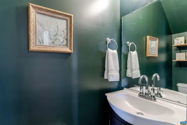 a bathroom with a sink a toilet and a mirror