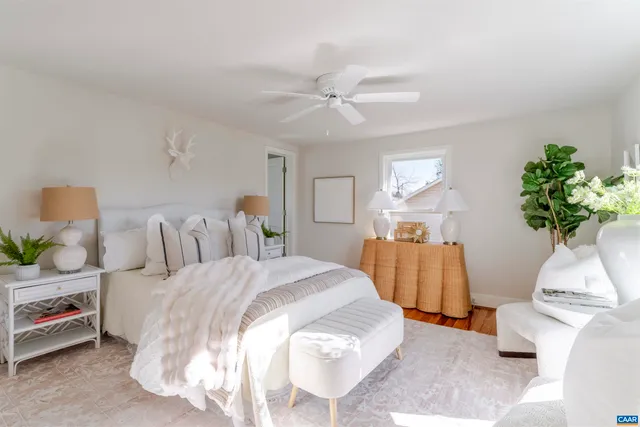 a view of a hallway with wooden floor and a bathroom