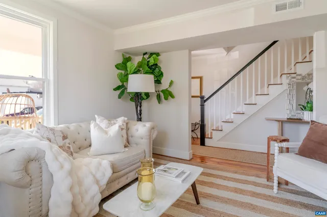 a living room with furniture flowers and a potted plant