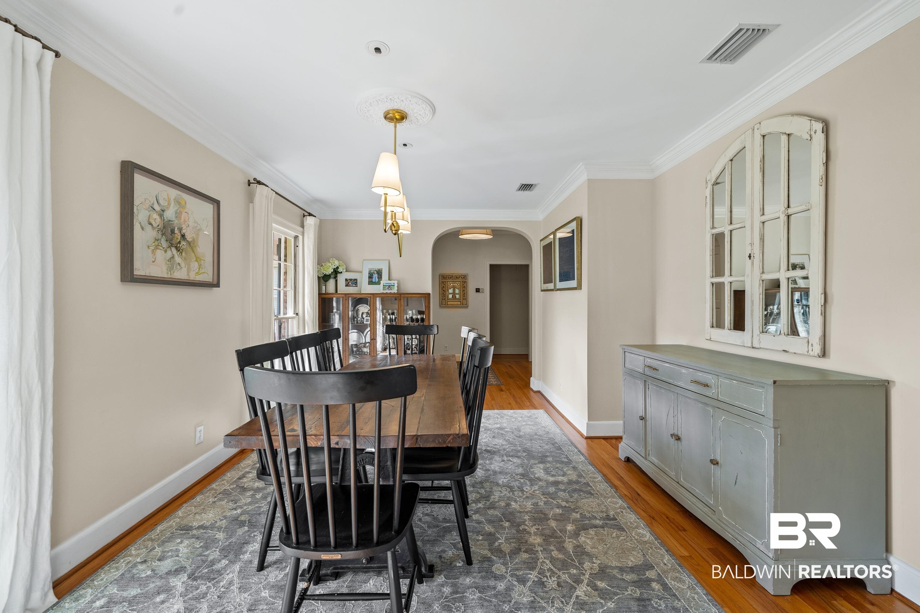 141 Myrtlewood Lane Mobile, AL 36608 - Photo 5 of 44 Dining space featuring arched walkways, baseboards, visible vents, and wood finished floors