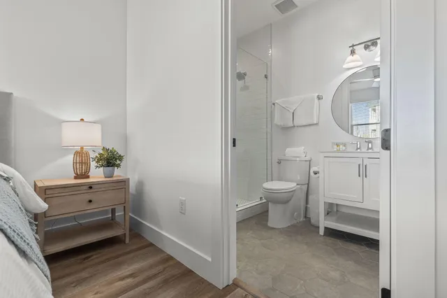 a bathroom with a toilet a sink a mirror and vanity