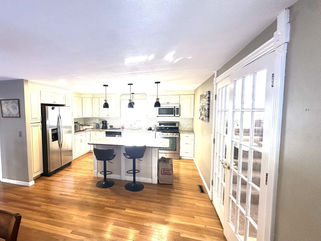 24 Seneca Drive Hudson, MA 01749 - Photo 13 of 30 a dining room with stainless steel appliances a dining table chairs and view of kitchen