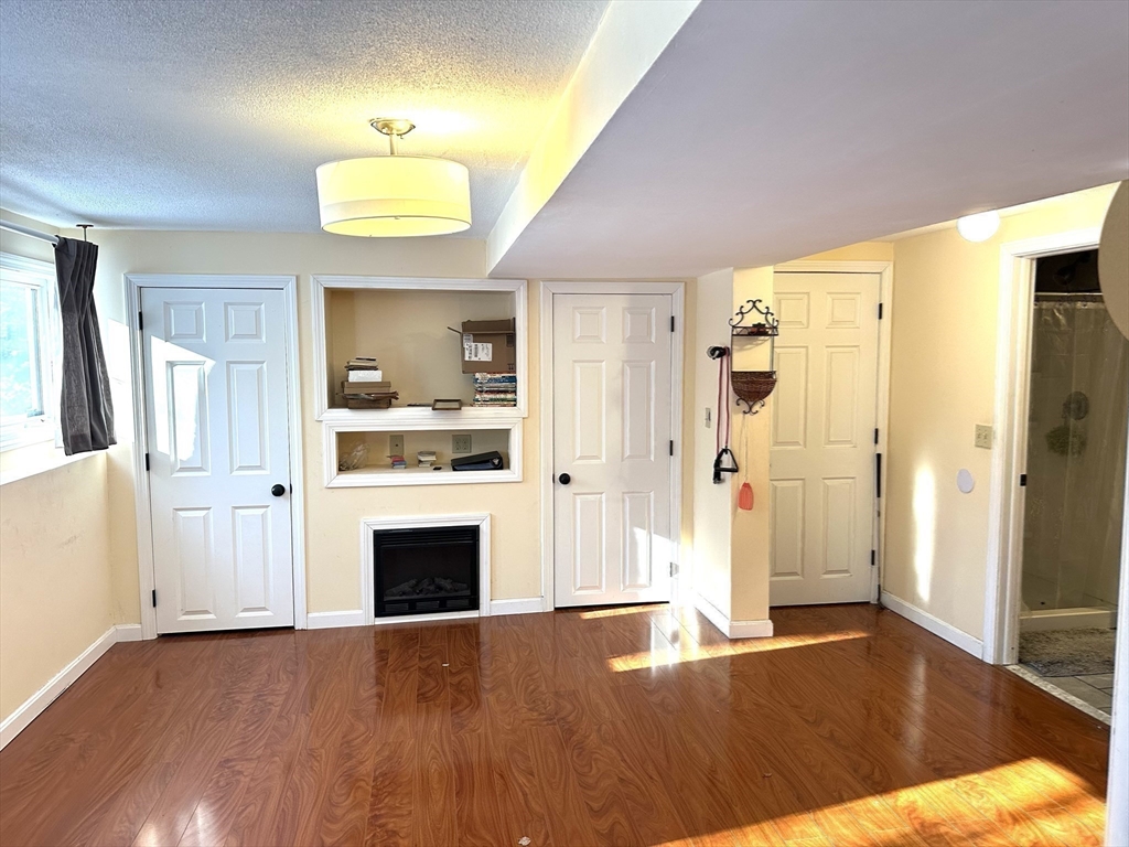 24 Seneca Drive Hudson, MA 01749 - Photo 17 of 30 a view of a livingroom with a fireplace wooden floor and window