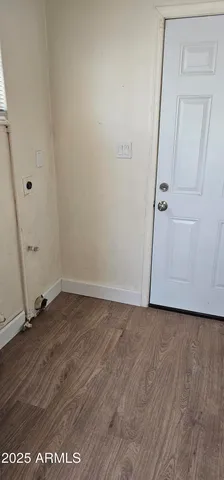 a view of a room with wooden floor and white wall
