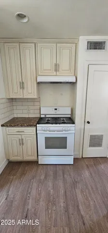 a kitchen with wooden floors and white appliances