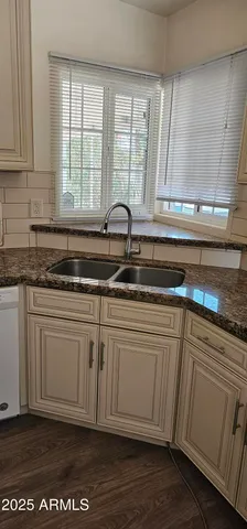 a kitchen with granite countertop white cabinets and a sink