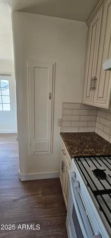 a kitchen with granite countertop a stove and cabinets