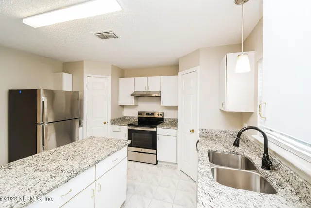 a kitchen with a refrigerator sink and stove