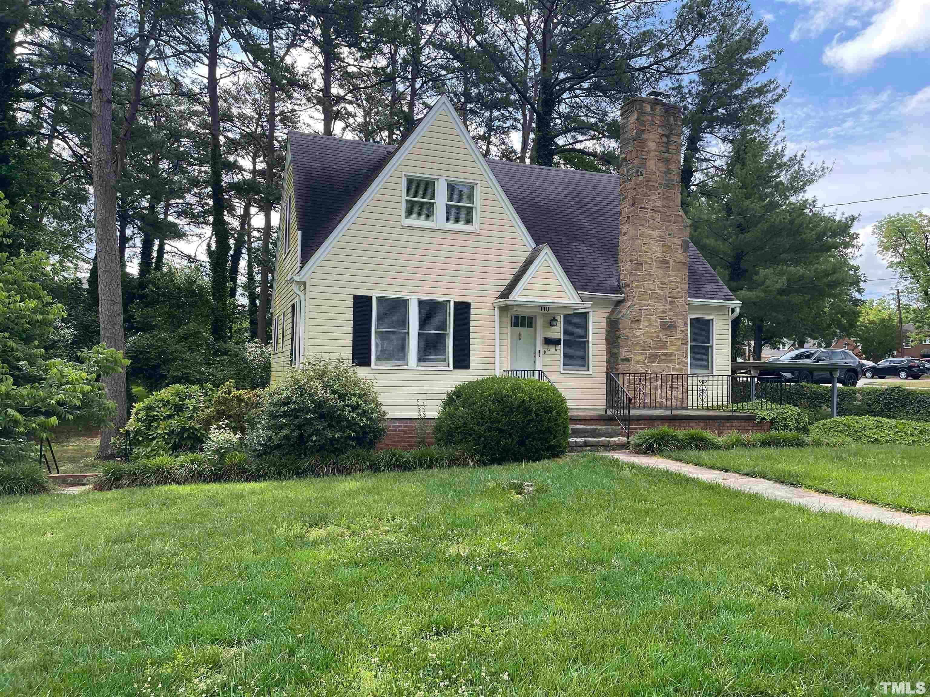 a front view of a house with a yard and trees