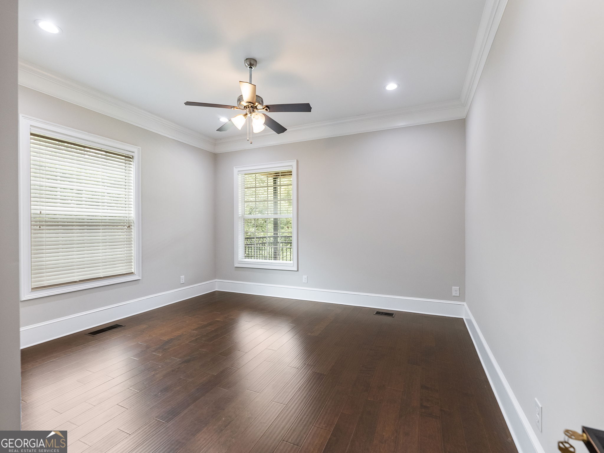 125 Iron Horse Trail Lula, GA 30554 - Photo 22 of 86 an empty room with wooden floor ceiling fan and windows
