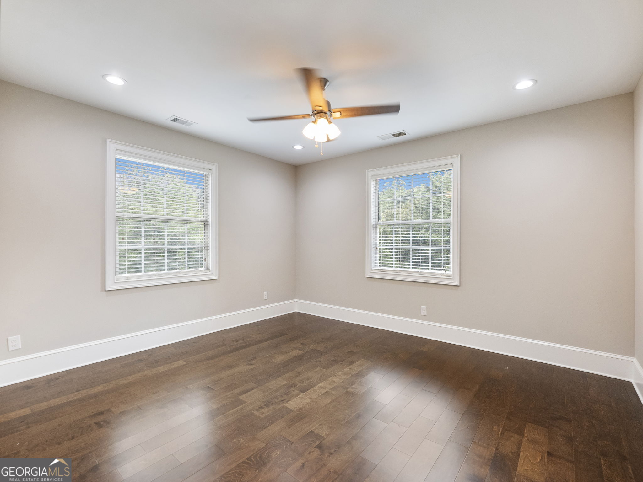 125 Iron Horse Trail Lula, GA 30554 - Photo 35 of 86 an empty room with wooden floor ceiling fan and windows