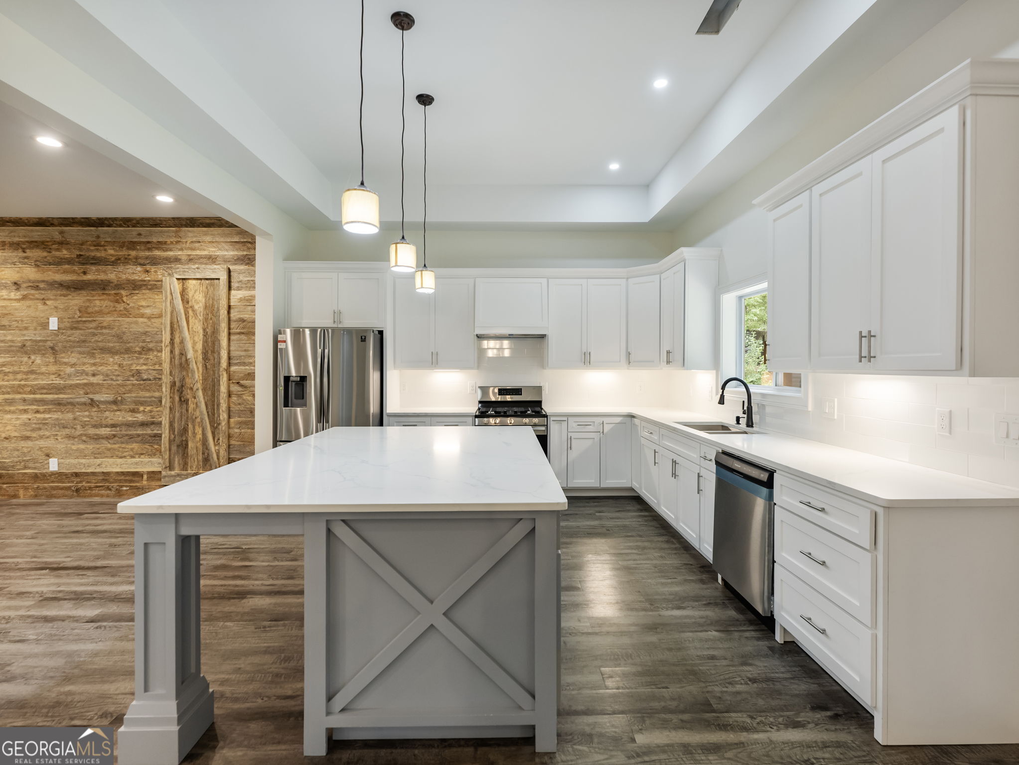 125 Iron Horse Trail Lula, GA 30554 - Photo 56 of 86 a kitchen with kitchen island a sink stainless steel appliances and cabinets