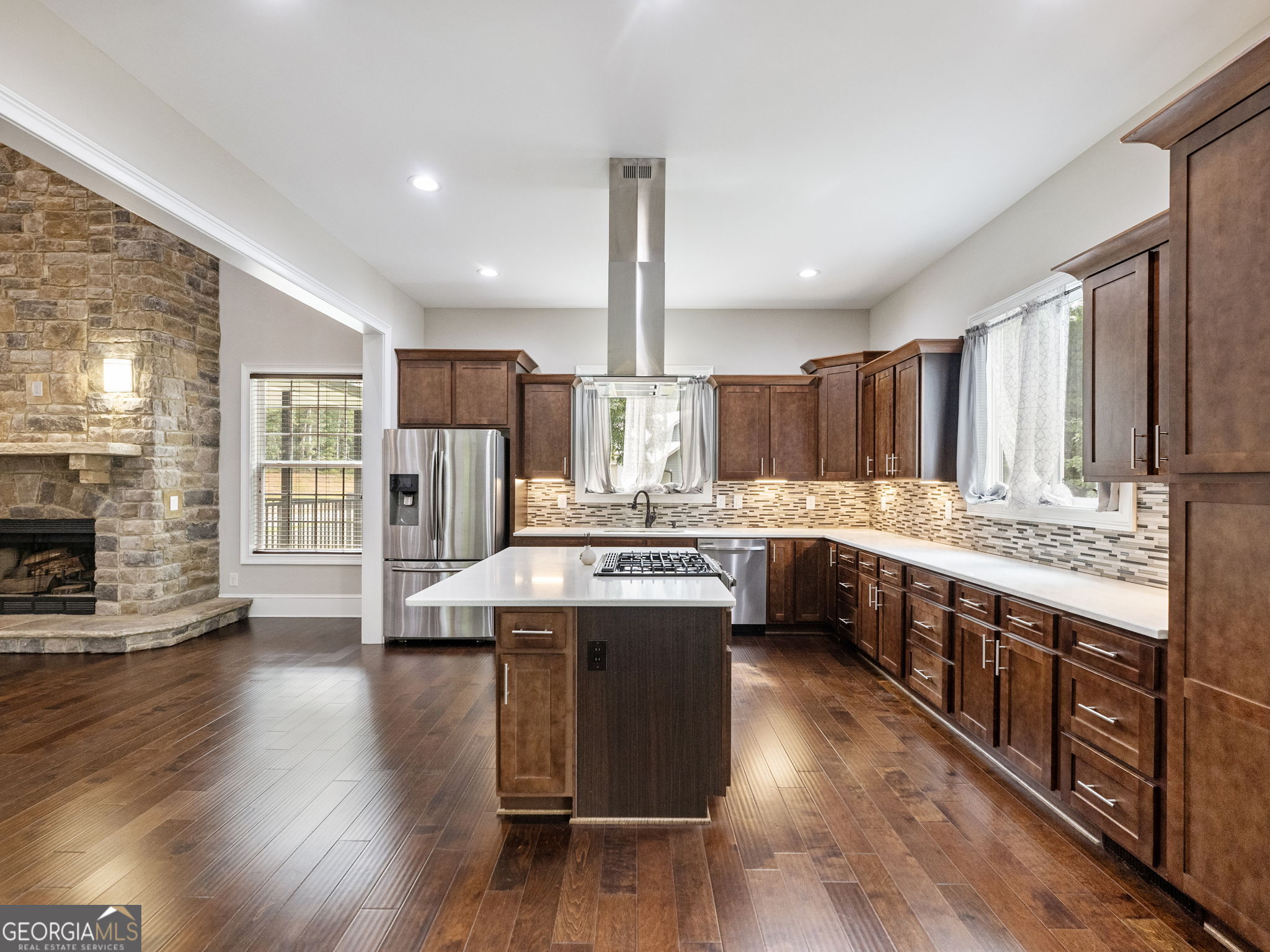 125 Iron Horse Trail Lula, GA 30554 - Photo 9 of 86 a kitchen with stainless steel appliances granite countertop wooden floors and white cabinets
