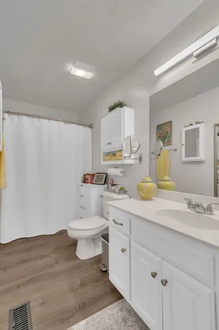 a bathroom with a granite countertop sink mirror vanity and toilet