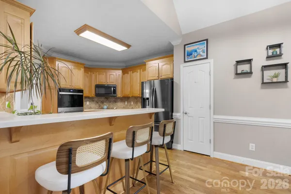 a kitchen with stainless steel appliances granite countertop a refrigerator and cabinets
