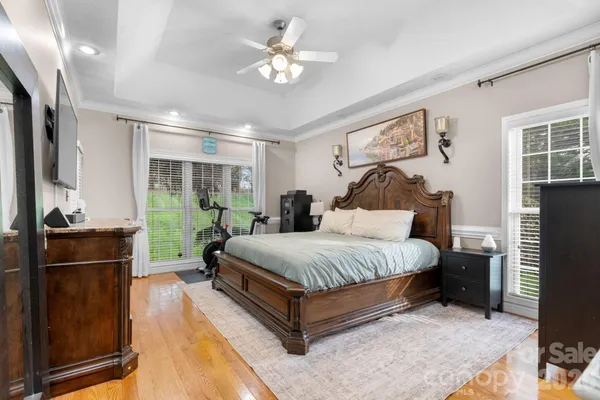 a spacious bedroom with a bed and wooden floor