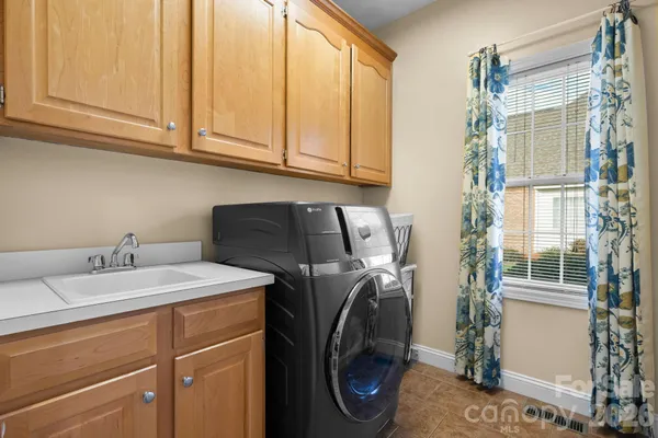 a utility room with sink dryer and washer