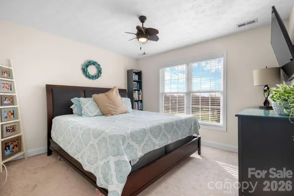 a bed sitting in a bedroom next to a window