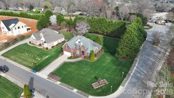 an aerial view of a house with a garden and large trees