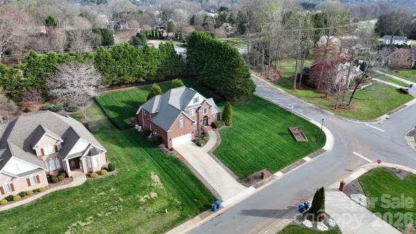 an aerial view of a house with a yard and lake