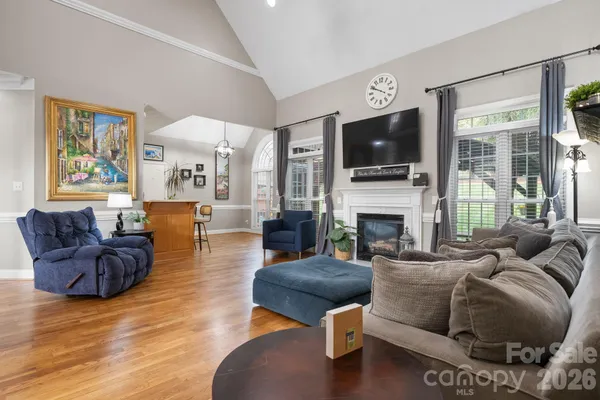 a living room with furniture a flat screen tv and a fireplace