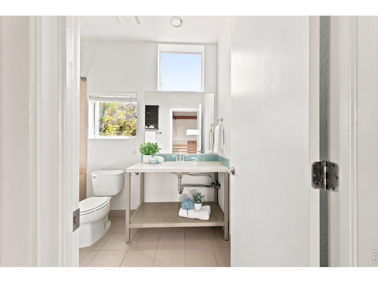 3033 Blake Street, Unit 112 Denver, CO 80205 - Photo 24 of 28 a bathroom with a sink a toilet and a mirror
