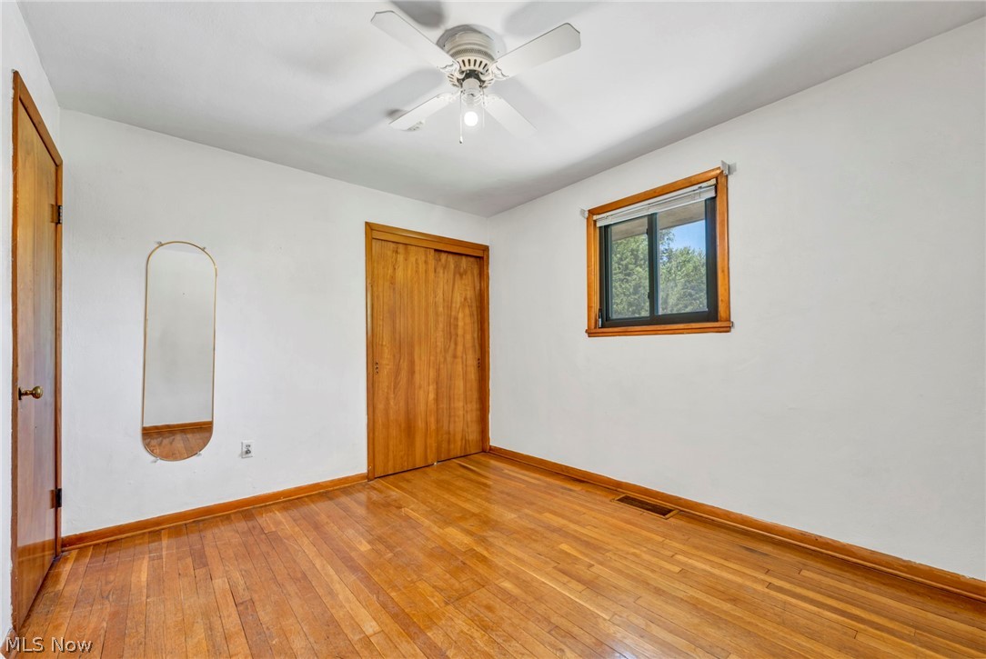 38450 Center Ridge Road North Ridgeville, OH 44039 - Photo 18 of 50 Unfurnished bedroom with ceiling fan, a closet, and hardwood / wood-style flooring
