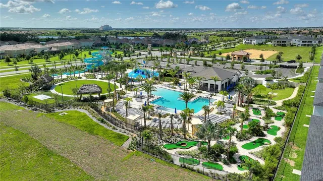 an aerial view of a swimming pool with outdoor seating and yard
